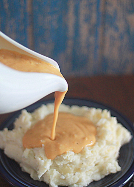 Vegetarian gravy being poured over mashed potatoes