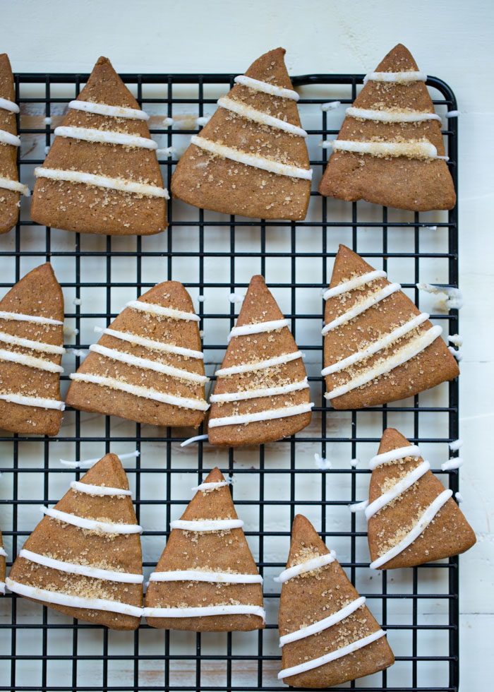 This easy Christmas cookie recipe is one of our favorites to make. Perfectly spiced dough, cut super-easily into tree shapes with a knife, then after they're baked and cooled, they finish up in a snap with quick lines of simple lemony icing and a sprinkle of coarse sugar for sparkle. Yum! #gingerbreadcookies