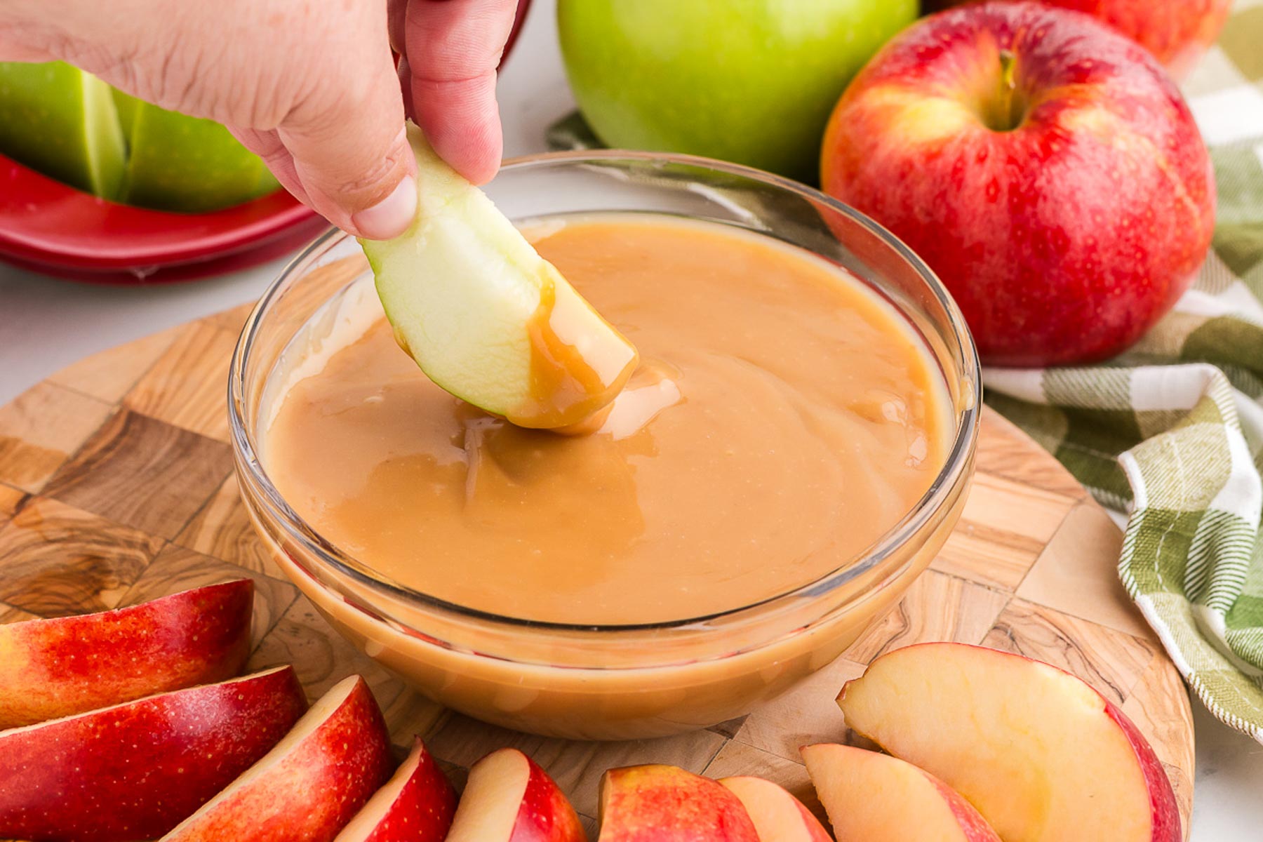 an apple dipped into caramel apple dip