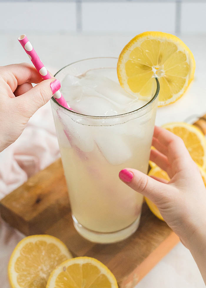 Stirring a glass of single serving lemonade by the glass
