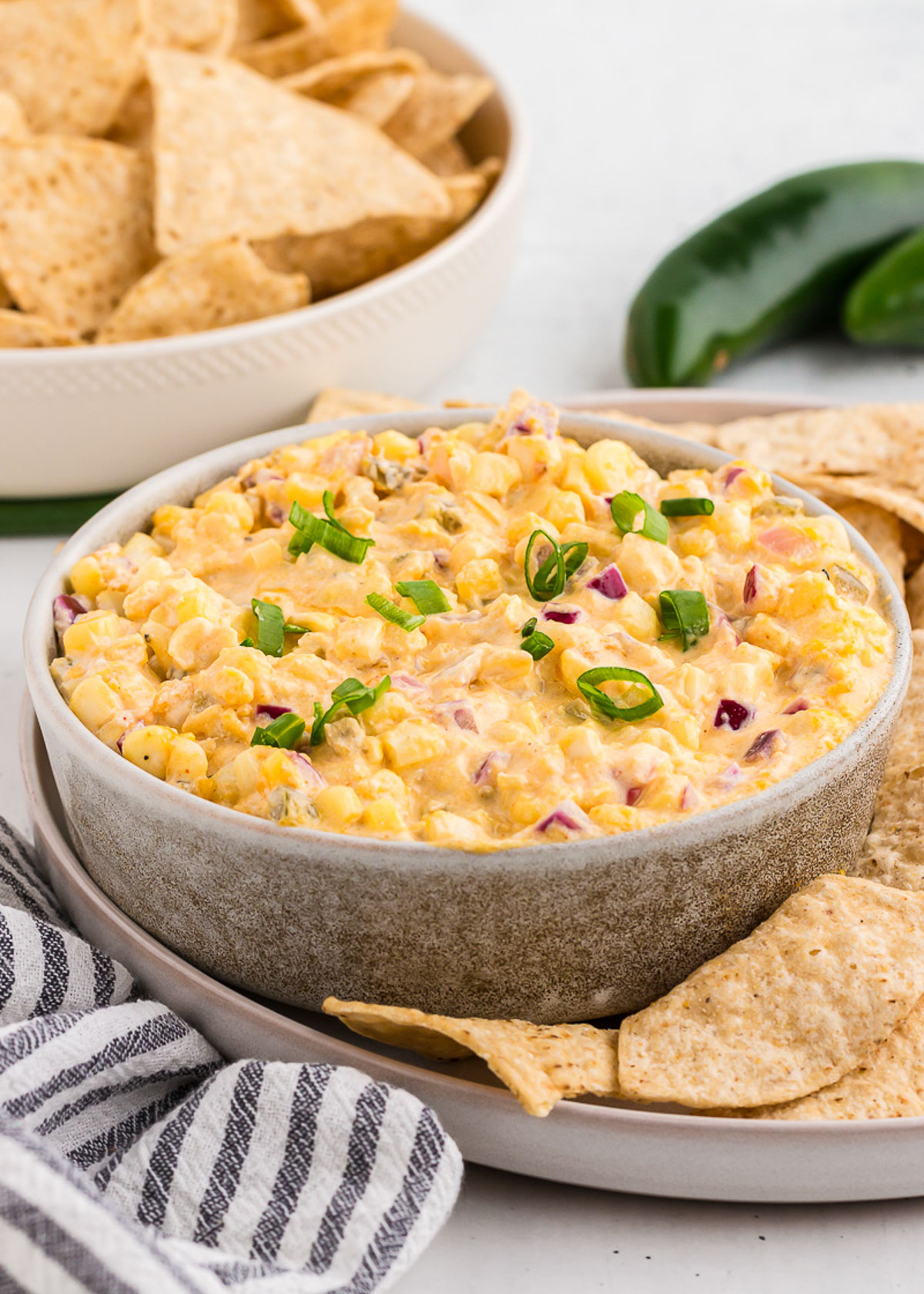 Mexican Corn Dip in a rustic bowl served with tortilla chips. 