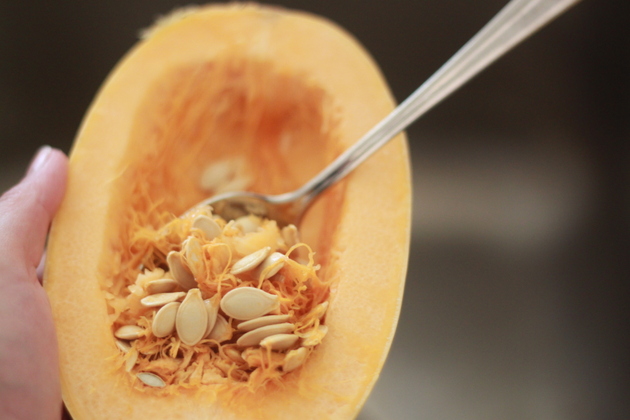 Spoon scraping the seeds out of the spaghetti squash