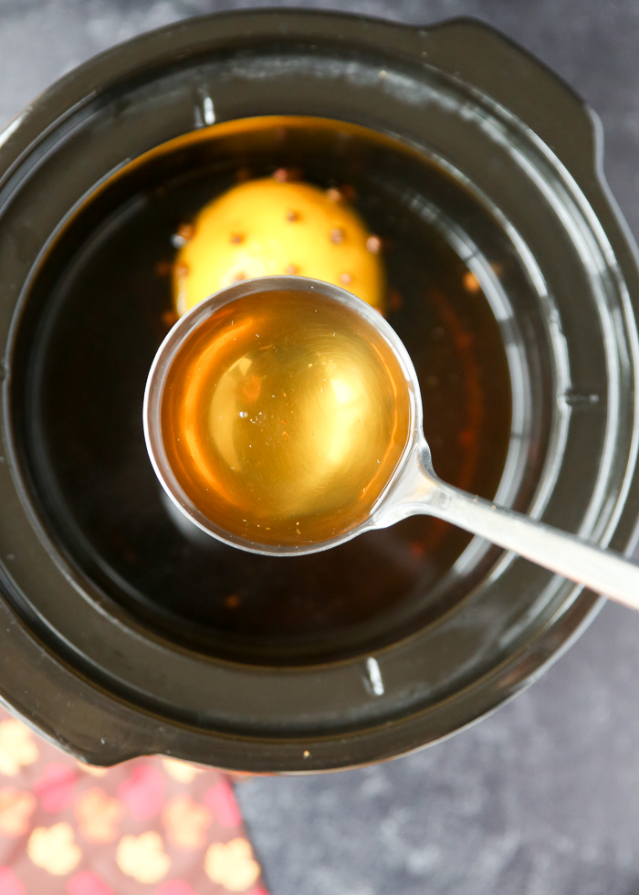 Ladleful of Crock Pot Hot Spiced Apple Cider in the slow cooker
