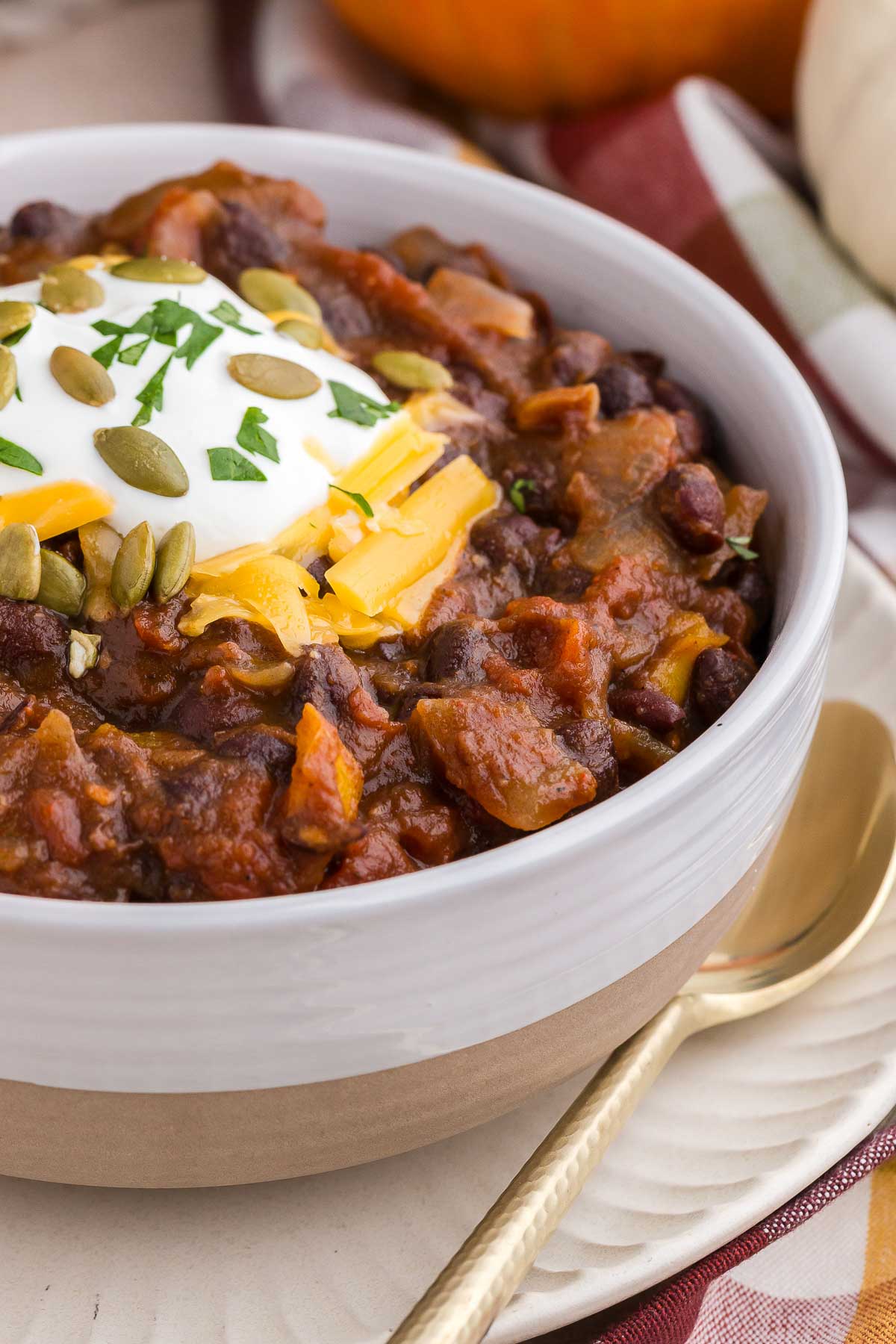 close up of a bowl of delicious pumpkin chili with toppings