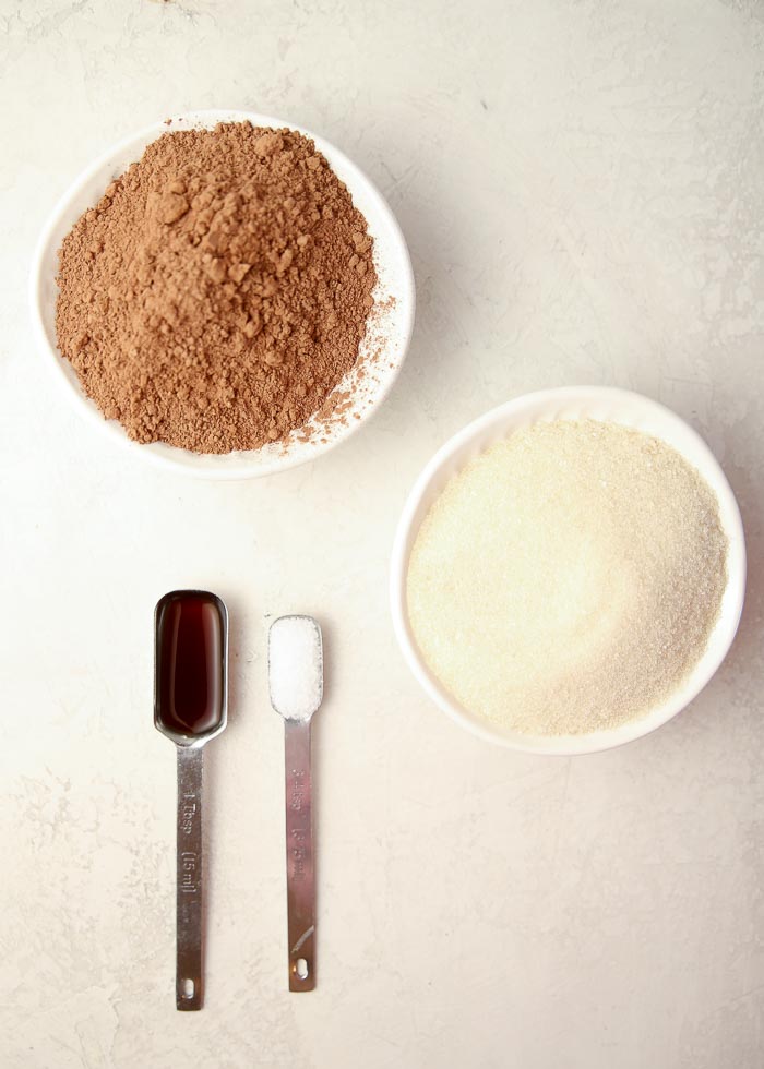 Ingredients for homemade chocolate syrup include cocoa powder, granulated sugar, pure vanilla extract, and salt. 