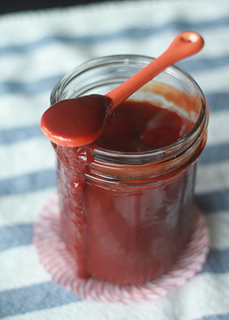 A jar of homemade barbecue sauce with a spoon. 