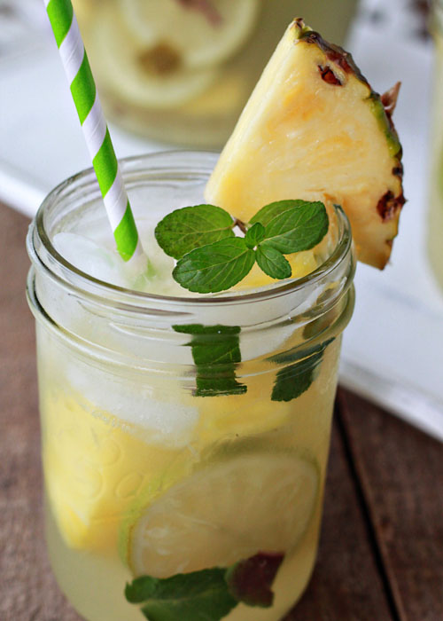 Pineapple Mojito Sangria - Boozy pineapple chunks mingle with muddled lime and fresh mint for a refreshing white wine sangria that's sure to be the hit of the party.