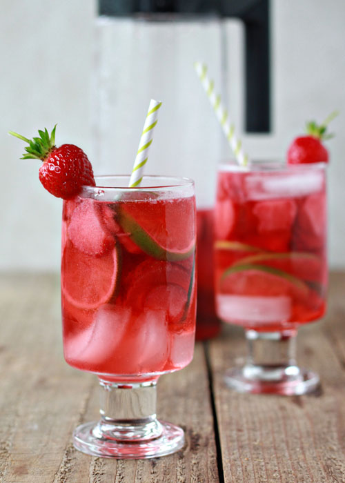 Strawberry Lime Rosé Sangria recipe - This light, refreshing, and simple sangria is perfect for sipping on a toasty summer afternoon. The bright ruby-red hue is compliments of starting with a nice pink rose wine, and then soaking strawberries in it. Lime adds a zesty bite, rum gives it a bit more potency, and lemon-lime soda mellows the whole thing out and makes it entirely too drinkable.