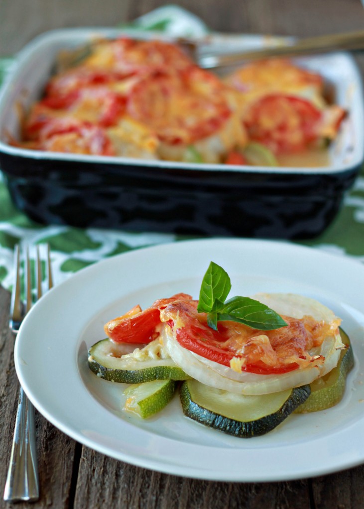 Mom's Cheddar Zucchini, Tomato, & Onion Gratin recipe - so easy! The quintessential summer side. Fresh-from-the-garden zucchini, tomatoes, and onions layered and covered with cheddar, then baked until tender and cheesy. Vegetarian with vegan option. 