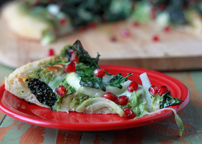 Kale & Pomegranate Pizza with Creamy Pesto Sauce recipe. Two doses of kale - both in the creamy, garlicky pesto and piled on top - make this vegetarian pizza a green powerhouse (in the most delicious way, promise!) Top with ruby-red pomegranate arils for color and a little irresistible sweet and salty contrast.