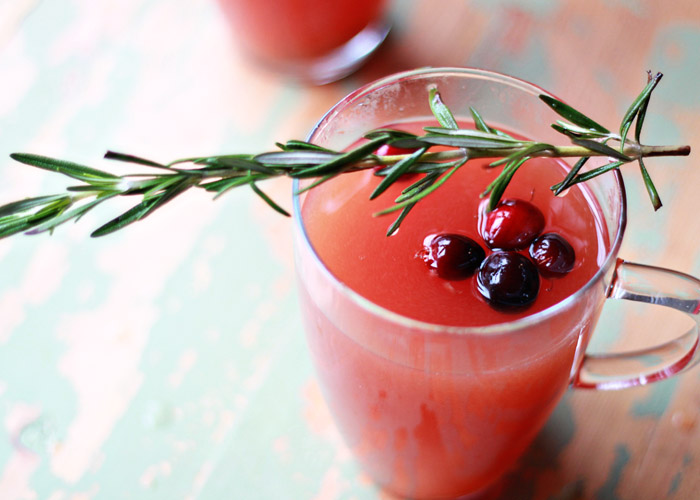 Slow Cooker Rosemary-Cranberry Mulled Cider - This Crock Pot spiced apple cider recipe gets its rosy glow - and an irresistible pop of flavor - from fresh cranberries. Rosemary adds an unexpected (and festive) vibe. 