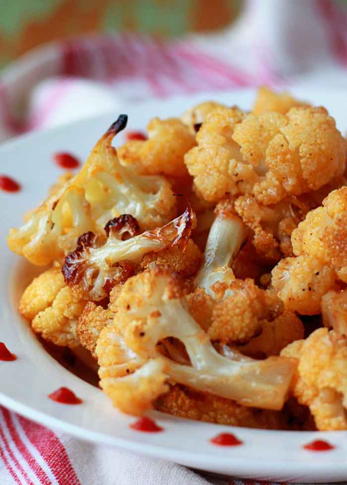 Maple-Sriracha Roasted Cauliflower recipe - Cauliflower, tossed in sweet maple syrup and spicy Sriracha, gets crispy-edged and caramelized in the oven. 