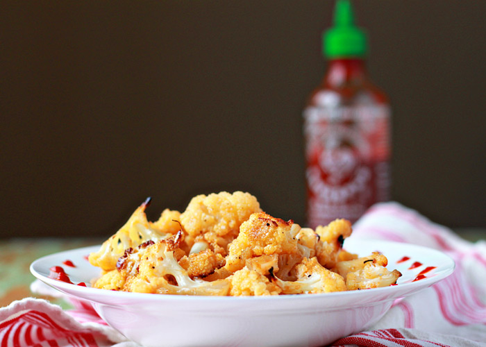 Maple-Sriracha Roasted Cauliflower recipe - Cauliflower, tossed in sweet maple syrup and spicy Sriracha, gets crispy-edged and caramelized in the oven. 
