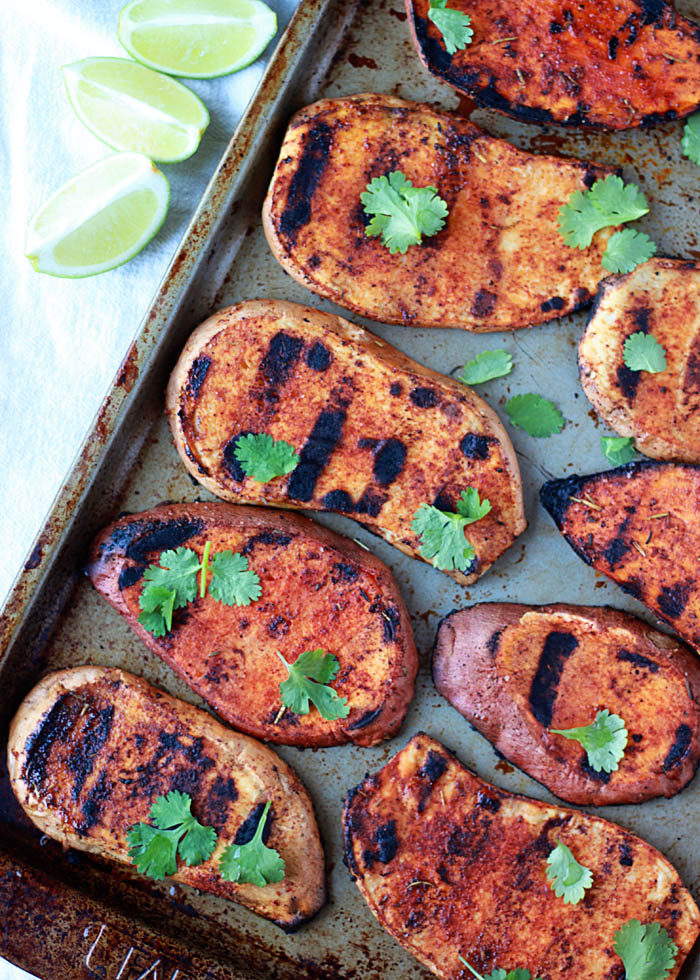 Sweet and Smoky Grilled Sweet Potatoes with Cilantro and Lime - Sweet potatoes on the grill? Heck yes! Thin-sliced sweet potato slabs grill up tender and perfect on the BBQ. Rub 'em with spices and top with cilantro and lime for the side of the summer.