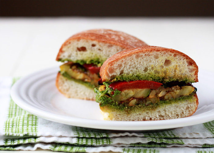 Grilled Summer Vegetable Sandwiches with Pesto - Summer in a vegan sandwich! Zucchini, summer squash, and red bell pepper doused in balsamic-thyme marinade, grilled to perfection, and then piled onto pesto-smeared artisan rolls.