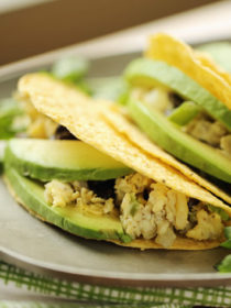 Scrambled eggs flecked with veggies and black beans, stuffed into a crunchy taco shell and topped with creamy avocado. These grab-and-go breakfast tacos are ready in 10 minutes flat! Gluten-free, dairy-free, and vegetarian (but with options for everyone!)