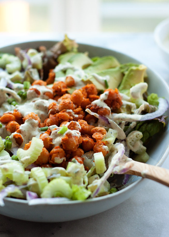 Vegan dairy-free Spicy Buffalo Chickpea Salad recipe - Addicting chickpeas, drenched in red hot sauce and then spooned over crisp lettuce and veggies. So good! But the kicker is that cool tahini ranch. I think this is my favorite salad ever. 