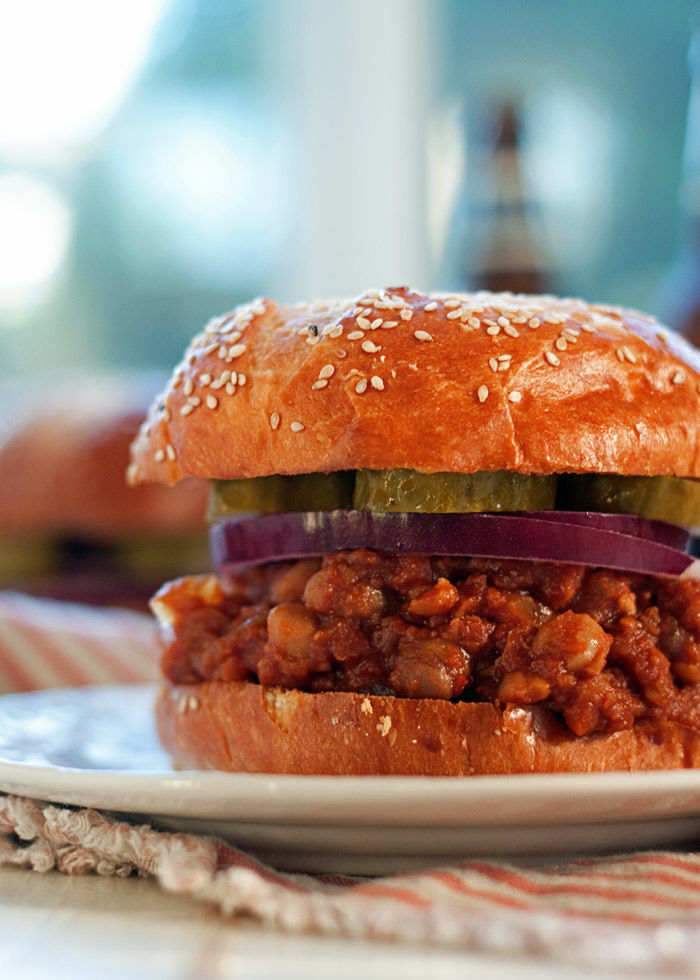 A close up of a vegetarian sloppy Joe with lentils and chickpeas inside a golden bun.