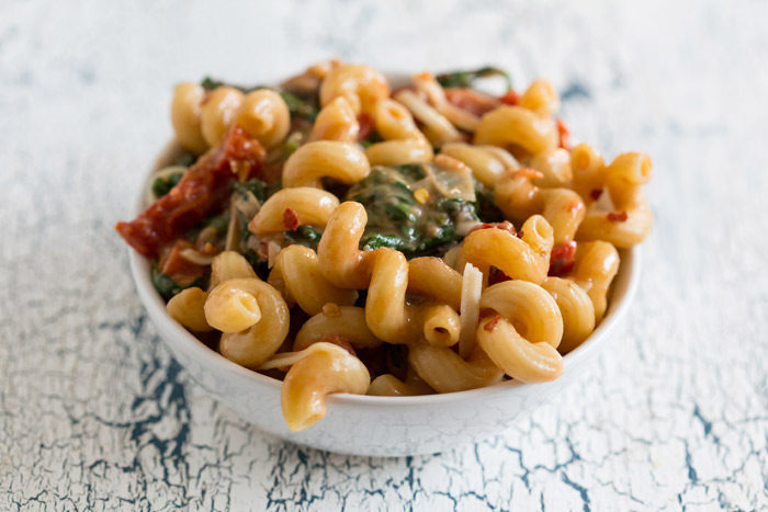 One-Pot Pasta Florentine recipe - This creamy pasta is loaded up with spinach, tomatoes, and Asiago cheese. Just 20 minutes from cutting board to table - and only one pot to clean! Vegetarian with chicken option. 