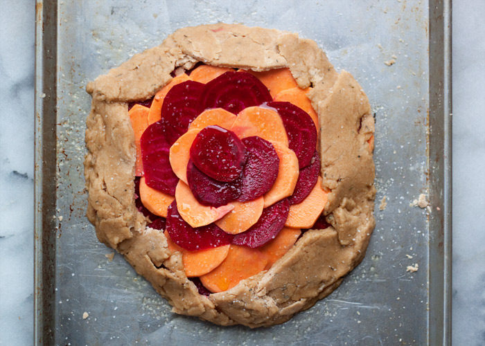 Rustic Sweet Potato & Beet Galette with Sea Salt & Herb Coconut Oil Crust vegan recipe - Thinly sliced sweet potatoes and ruby-red beets top a tender sea salt and herb coconut oil crust. This vegan entree is definitely worthy of a spot at your holiday table - and the best part is you don't have to worry about making it look perfect. The more rustic the better!