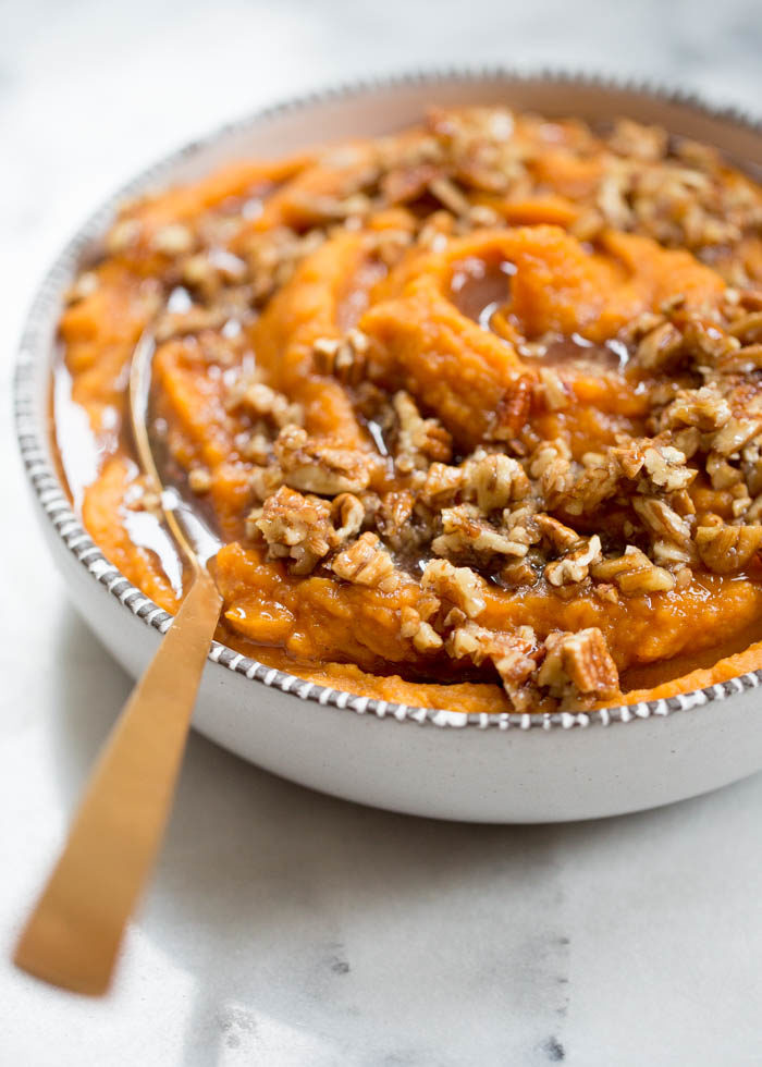 Sweet potatoes simmered in coconut milk until tender, whipped until smooth, and topped with a warm maple syrup and pecan mixture. Dairy-free and delicious! #veganthanksgiving #veganthanksgivingsides #sweetpotatoes #dairyfreethanksgiving