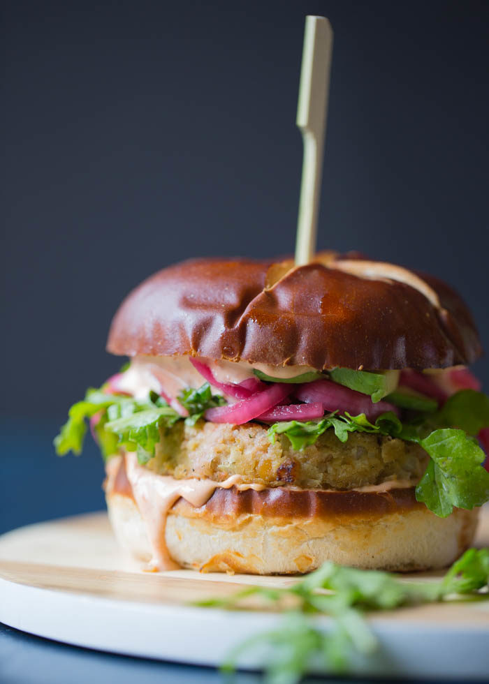 A tall chickpea veggie burger with a wooden skewer