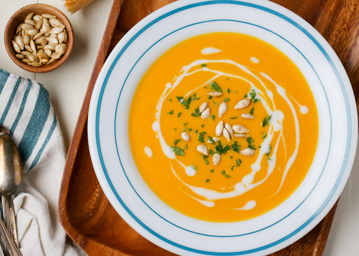 Simple Butternut Squash soup - A gorgeous, velvety soup that's full of flavor. It's oh-so easy to make, too - no peeling or dicing, just roast your butternut halves, peel off the skin, an blend the squash with ginger, vegetable broth, coconut milk, and a tiny splash of maple syrup. Yummmm. 