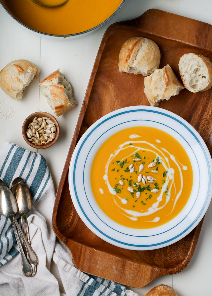 Simple Butternut Squash soup - A gorgeous, velvety soup that's full of flavor. It's oh-so easy to make, too - no peeling or dicing, just roast your butternut halves, peel off the skin, an blend the squash with ginger, vegetable broth, coconut milk, and a tiny splash of maple syrup. Yummmm. 