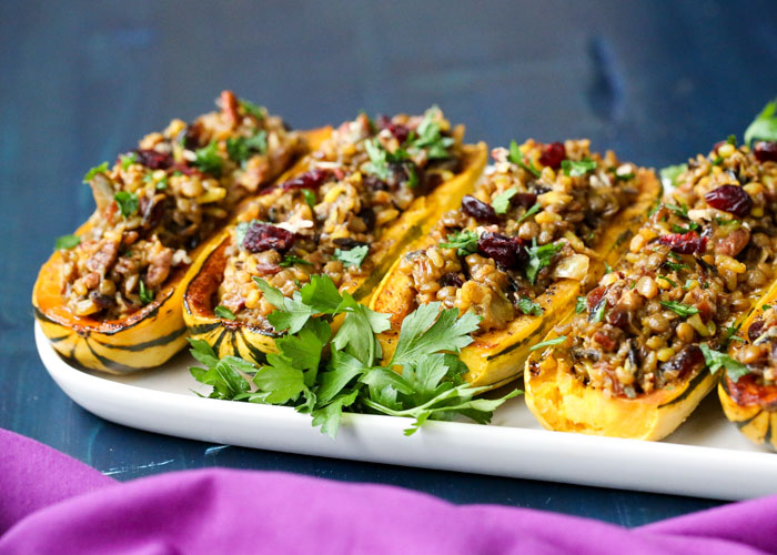 Wild Rice & Lentil Stuffed Delicata Squash with Cranberries & Pecans - Wild rice pilaf heartied up with lentils, flavored with curry spices and cumin, and dotted with sweet dried cranberries and crunchy pecans - all served up in delicious roasted delicata squash halves. Yum!