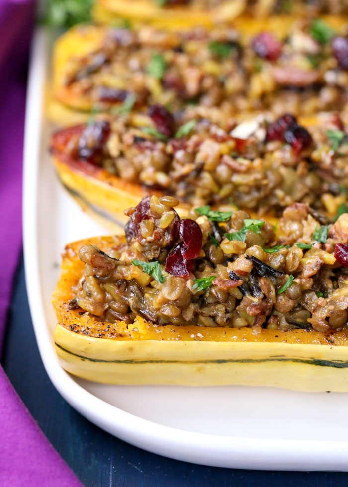 Close up of roasted stuffed Delicata Squash with pilaf studded with dried cranberries and pecans