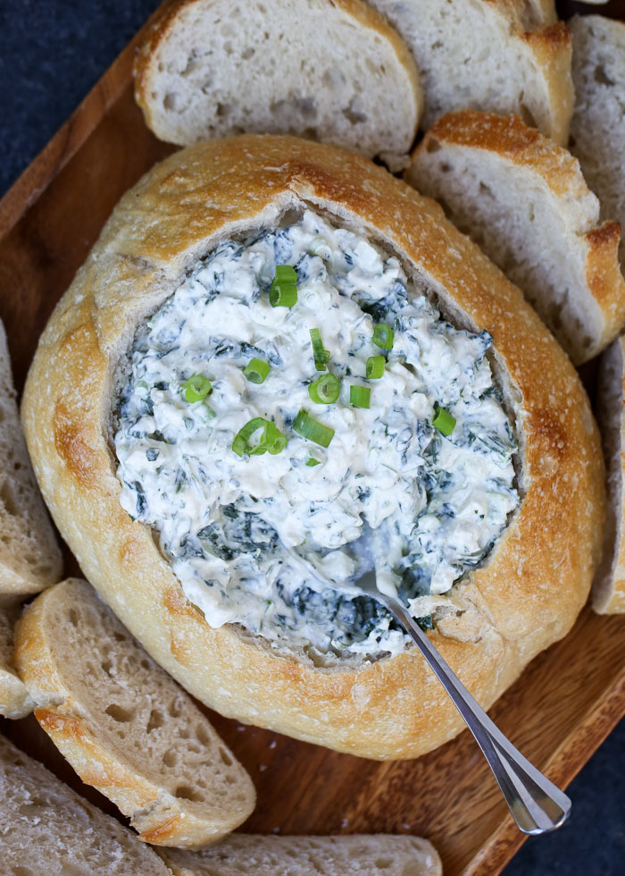 Spinach dip with water chestnuts served in a sourdough bread bowl