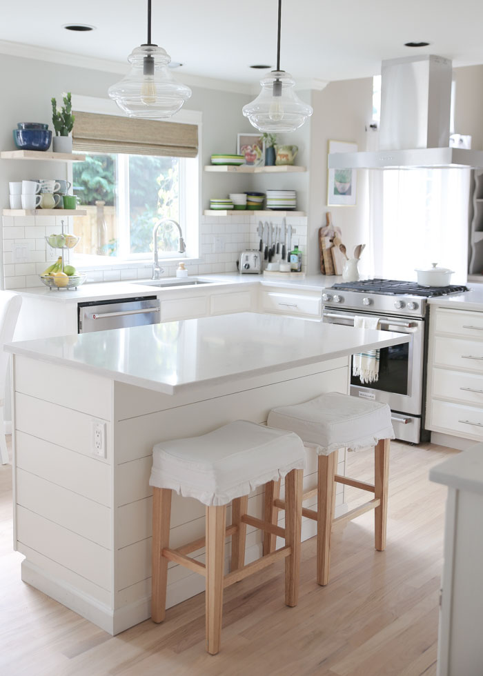 Budget-friendly white kitchen remodel. White quartz countertops, painted cabinets, whitewashed wood floors