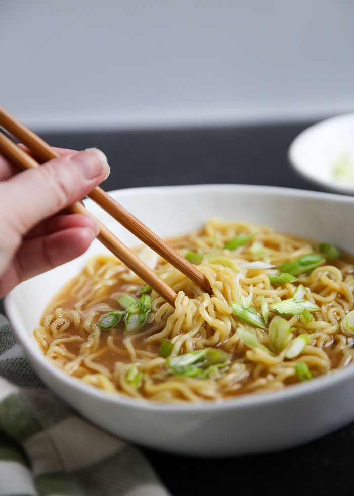 A bowl of simple vegan miso ramen being eaten with chopsticks