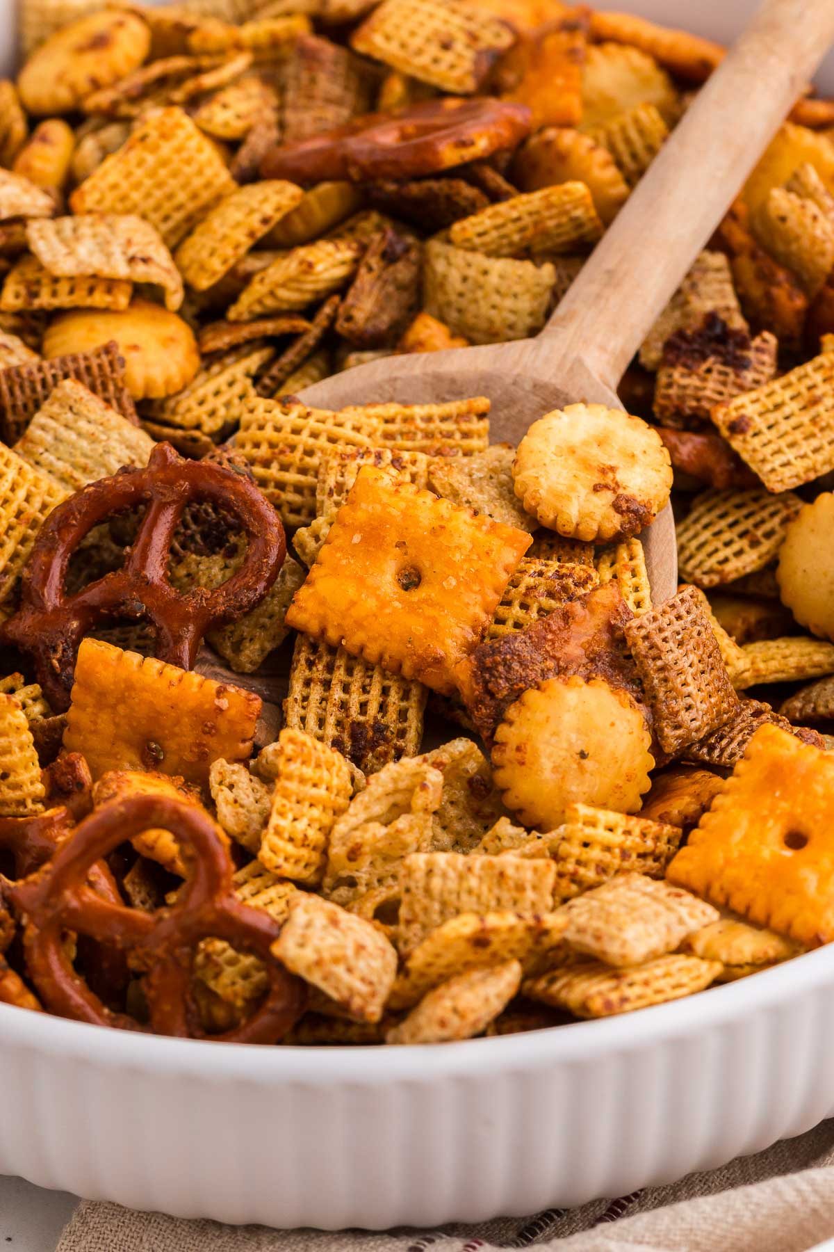 ranch Chex mix in a white bowl with a wooden spoon
