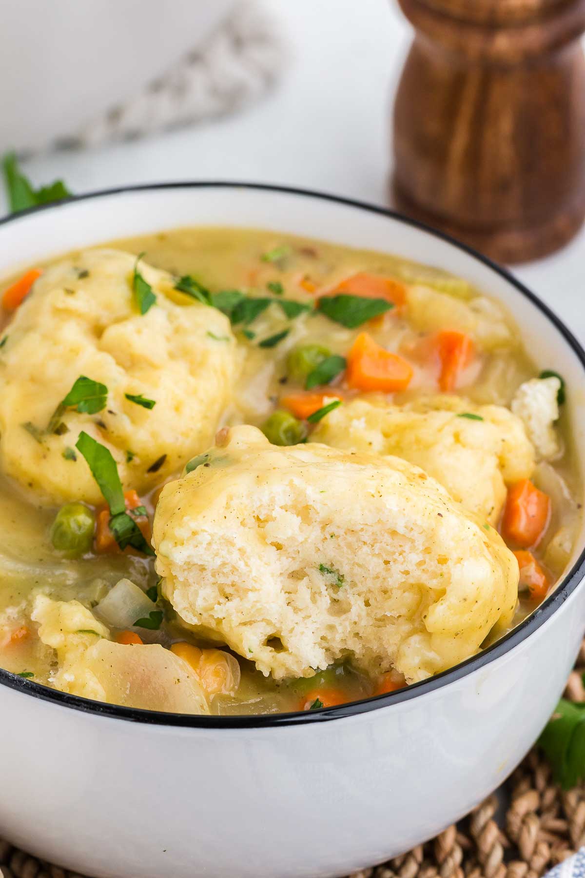 A close-up of vegetarian chicken and dumplings in a white pot.