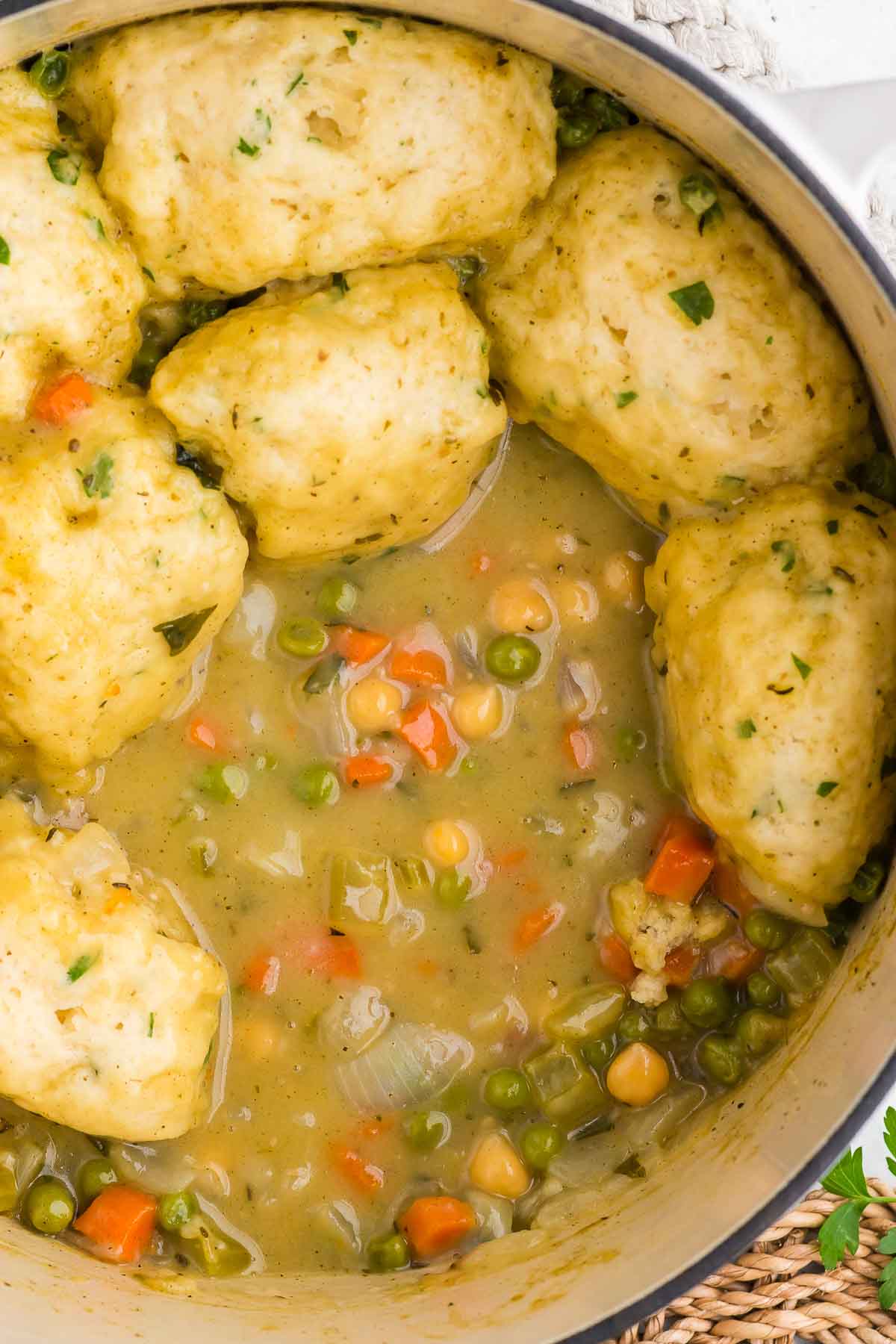 Top view of Vegetarian chicken and dumplings  in a pot with a dumpling missing to show the stew.