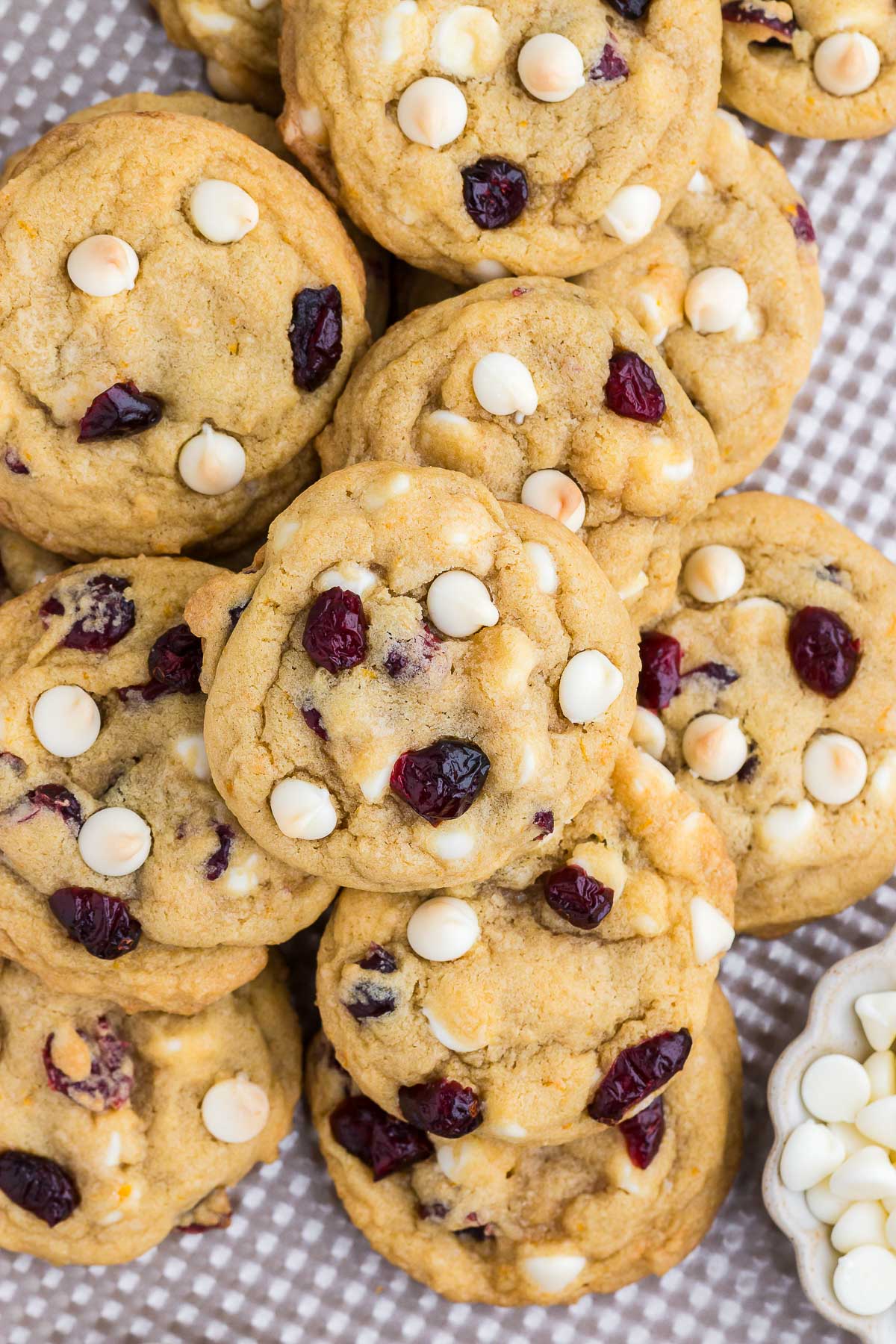 Top view of a pile of Cranberry Orange White Chocolate Chip Cookies on a metal baking sheet