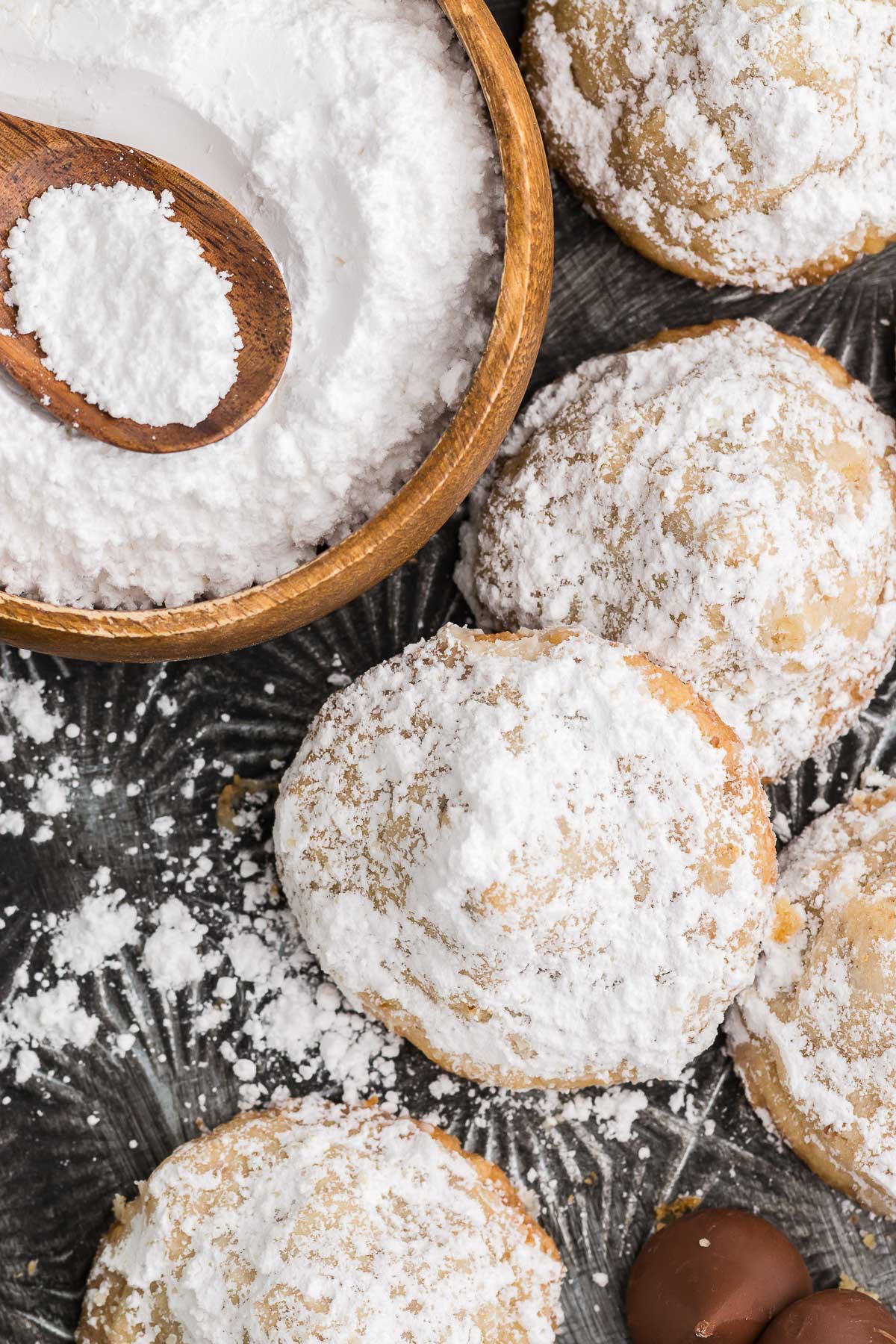 Top view of Hidden Kiss Cookies with a bowl of powdered sugar