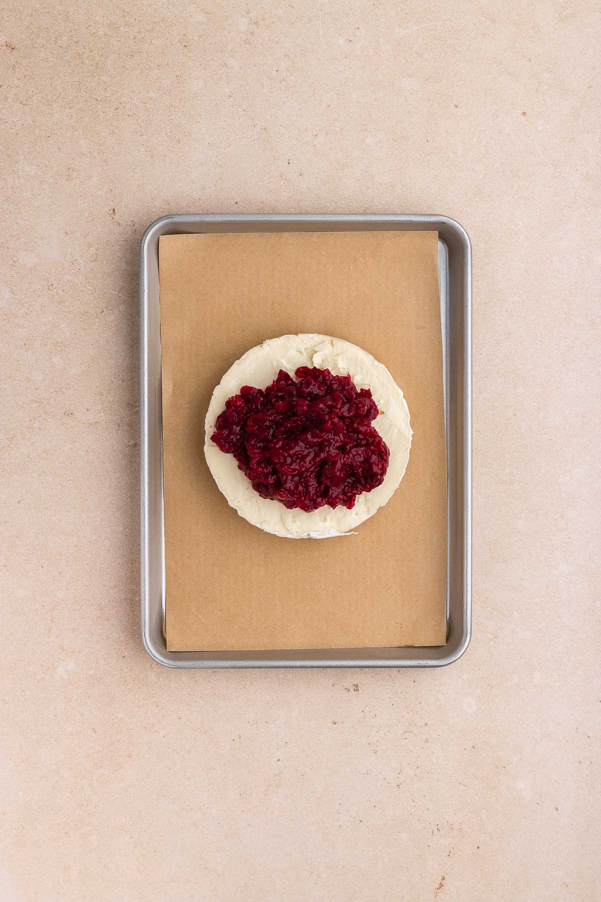 topping brie with cranberry sauce