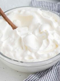 A glass mixing bowl full of freshly whipped cream