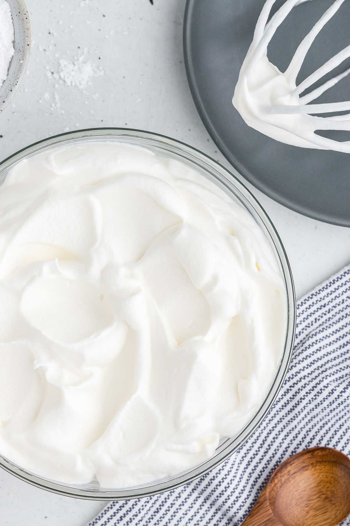 a top view of a bowl of whipped cream along with a whisk