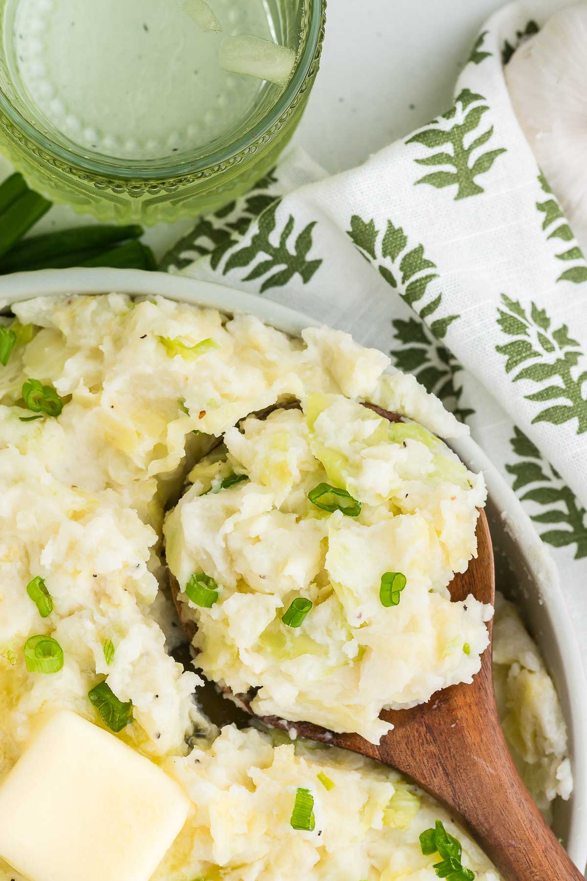 A wooden spoon scoops out a serving of colcannon Irish cabbage and mashed potatoes