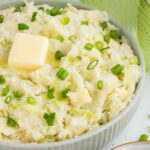 White bowl full of Irish colcannon potatoes with butter and scallions
