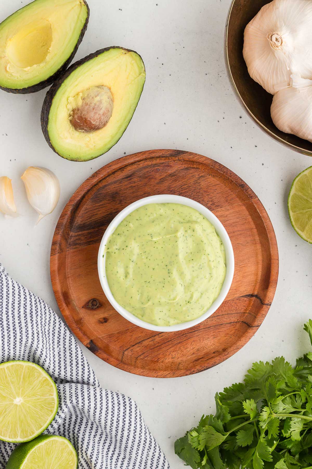 A bowl full of Avocado Lime Crema on a wooden tray