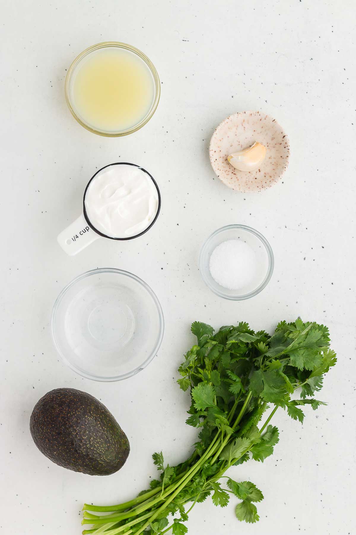 Ingredients for A wood and silver spoon scoops out a serving of Avocado Lime Crema
