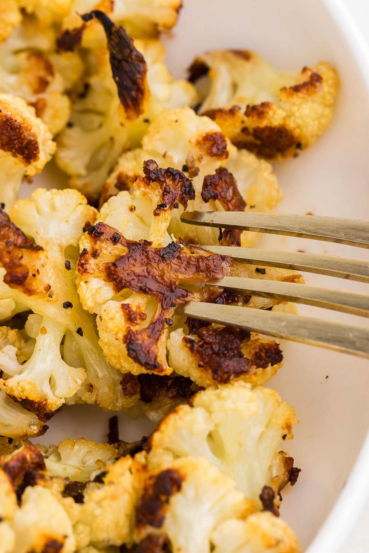 A fork pierces a piece of Roasted Cauliflower