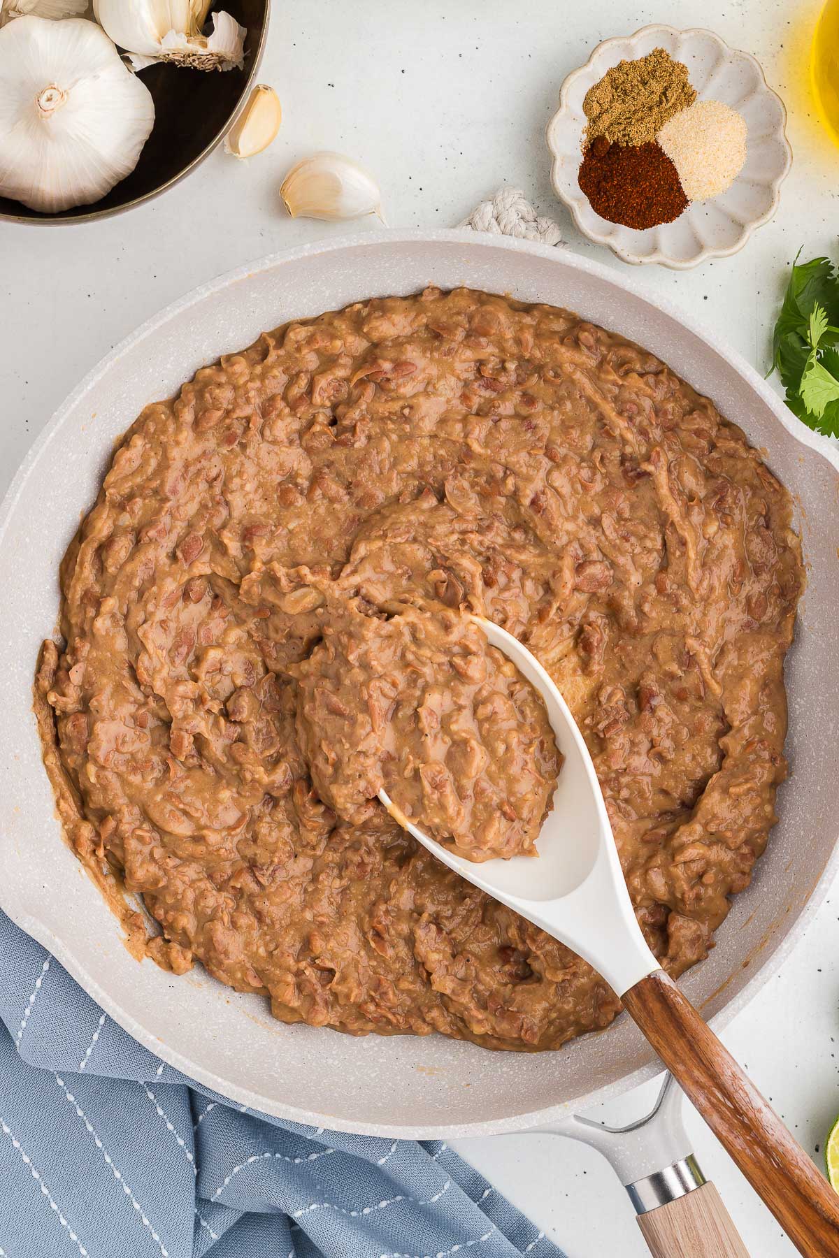 A spoon scoops up a serving of Homemade Refried Beans
