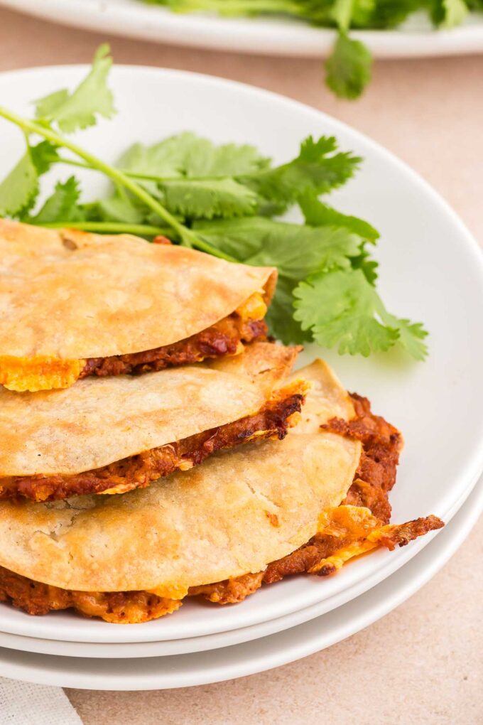 crispy refried bean tacos on a white plate
