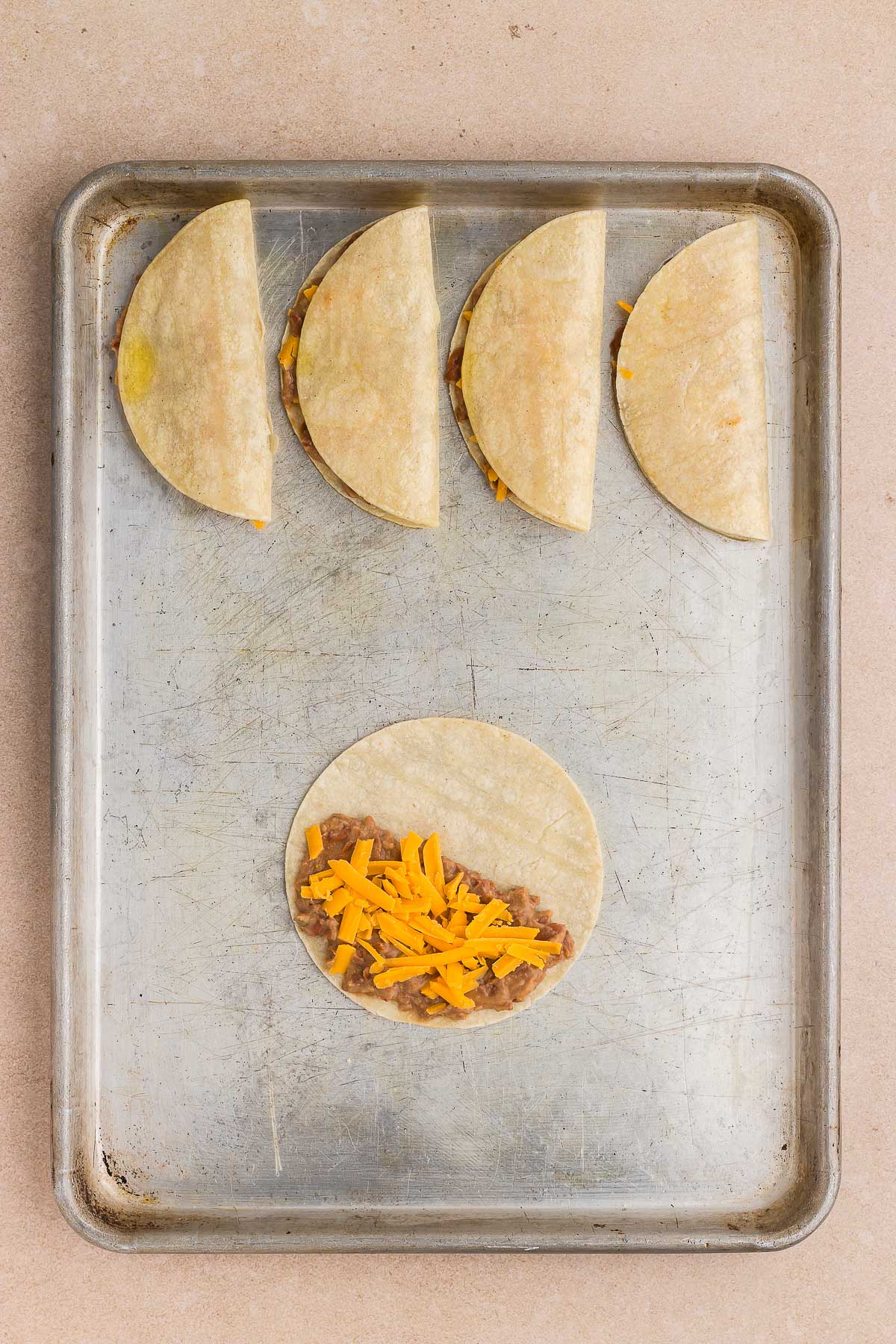 filling the tortillas for crispy refried bean tacos