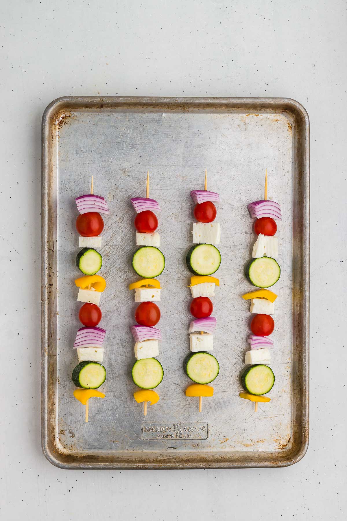 Assembled halloumi and vegetable skewers ready to grill